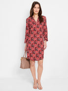 Red, brown, and white geometric print knee-length dress with 3/4 sleeves and V-neck.