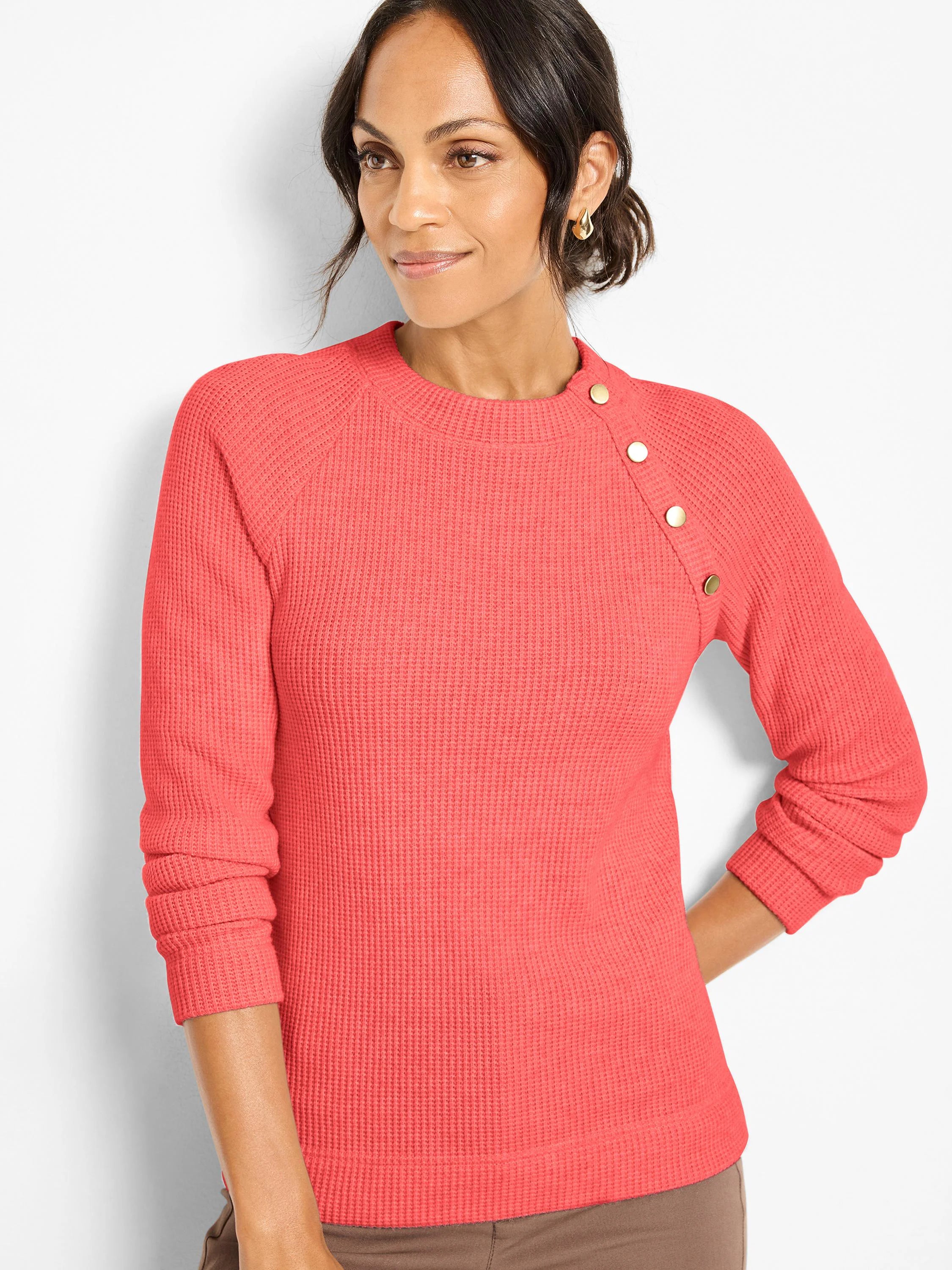 Coral thermal waffle knit long-sleeve top with gold buttons on the left shoulder.