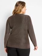Woman in dark brown long-sleeve knit top with subtle metallic flecks, viewed from the back.