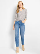 Mélange cream and grey knit polo top with V-neck, collar, and long sleeves.