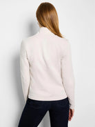 Back of a pale cream, high-neck jacket with long sleeves.