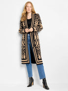 Black ribbed tank top with subtle sheen, partially visible under a long black and tan patterned cardigan.