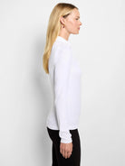 White long sleeve ribbed knit polo shirt with a collar, worn by a model in profile.