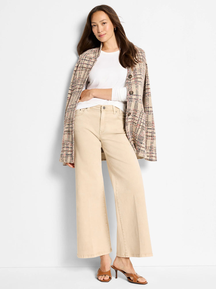 White, round-neck, long-sleeve knit top worn by a model, partially covered by a plaid jacket and beige pants.