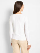 White long-sleeve top, back view. Features a rounded neckline and soft knit fabric.