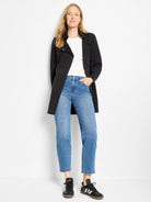 Black mid-thigh length jacket with notched lapels. Features two visible front snaps, shown worn open.