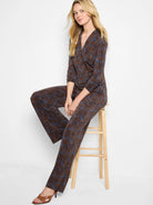 Brown & blue feather fern print V-neck wrap top with 3/4 sleeves, worn with matching pants.