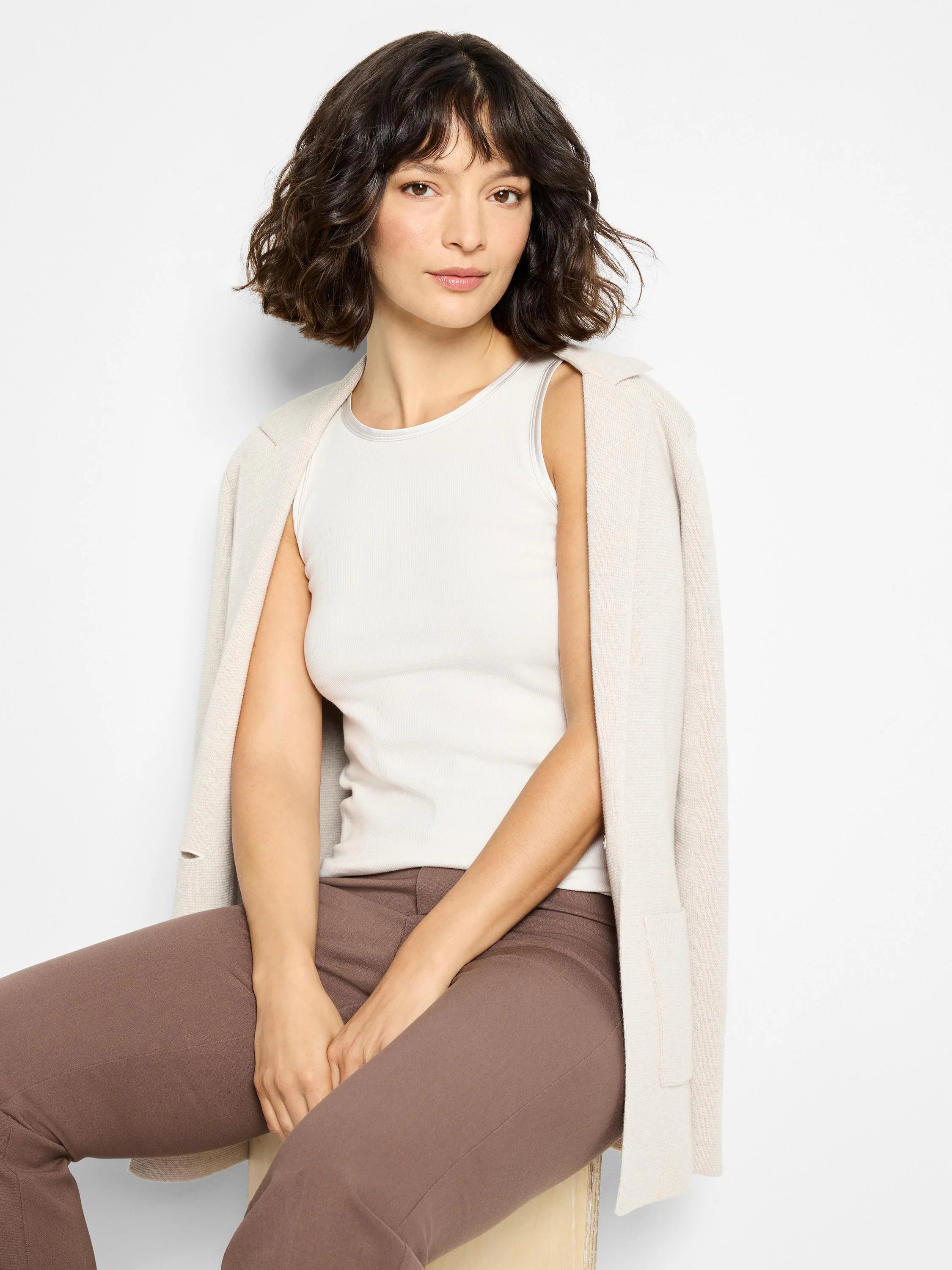 Off-white ribbed tank top with silver-toned trim at the neckline and armholes.
