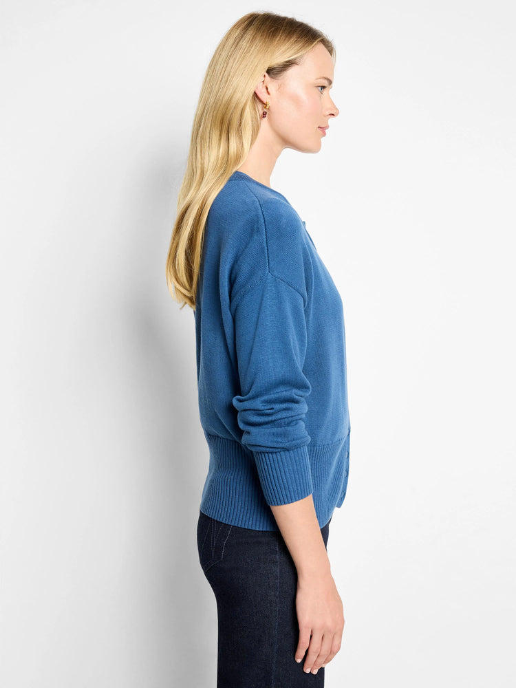 Deep blue pure cotton cardigan with long sleeves, ribbed cuffs and hem. Shown in profile.