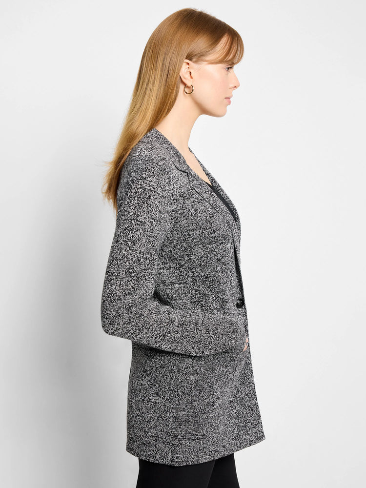 Black and white speckled knit blazer with notched lapels and a single-button closure, shown on a model.