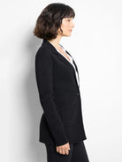 Black knit blazer with single button, notched lapels, and patch pockets.