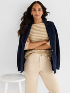 Navy knit blazer and beige striped top paired with high-waisted khaki pants achieve a relaxed, tailored look.