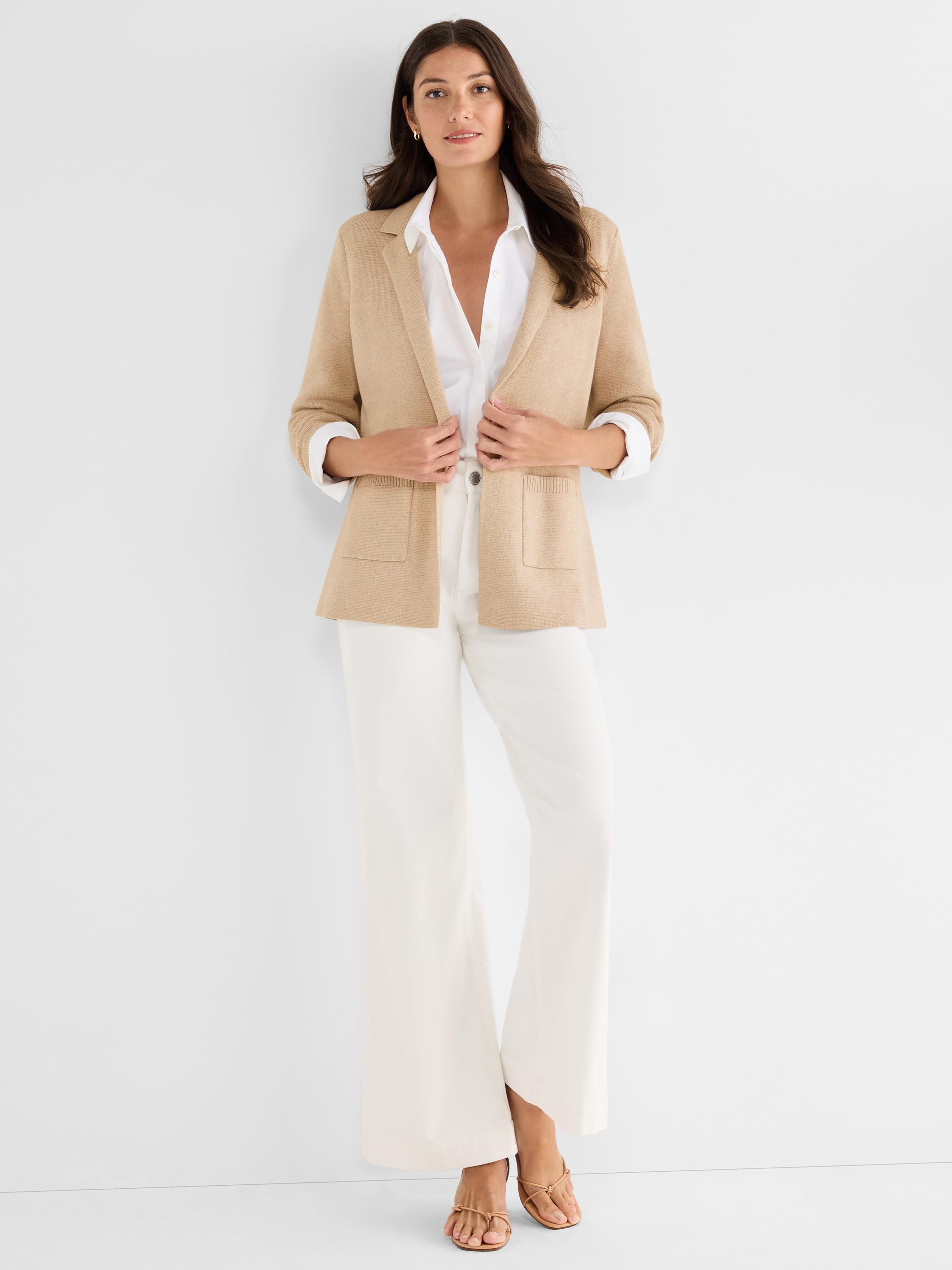 Relaxed tan knit blazer featuring soft notch lapels, open front styling, and large functional front patch pockets.