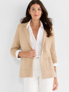 The model wears a tan knit blazer with notched lapels, a standard fit, and functional patch pockets.