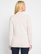 Back view of a light beige knit blazer. Ribbed texture, collar, center back seam, mid-hip length.