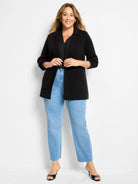 Black knit blazer, open front, with a lapel collar and two front patch pockets.