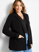 Black knit blazer with visible texture, notched lapels, and two large front patch pockets.