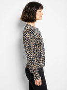 Navy, tan, and black long-sleeved cardigan with leopard print, shown worn in profile.