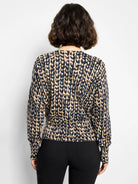Back of cardigan: navy and tan stitch print, long sleeves, gathered elasticated hem.