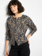 Round neck cardigan in navy and tan leopard print, featuring snap front closure.