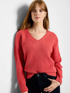Reddish-orange V-neck sweater with a distinct tuck stitch knit texture, ribbed cuffs and hem.