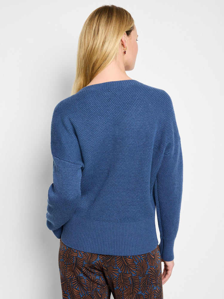 Blue tuck stitch sweater, relaxed fit, back view with ribbed cuffs and hem.