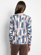 Back view of a waffle knit sweater with abstract blue, pink, white, and yellow brushstroke pattern.
