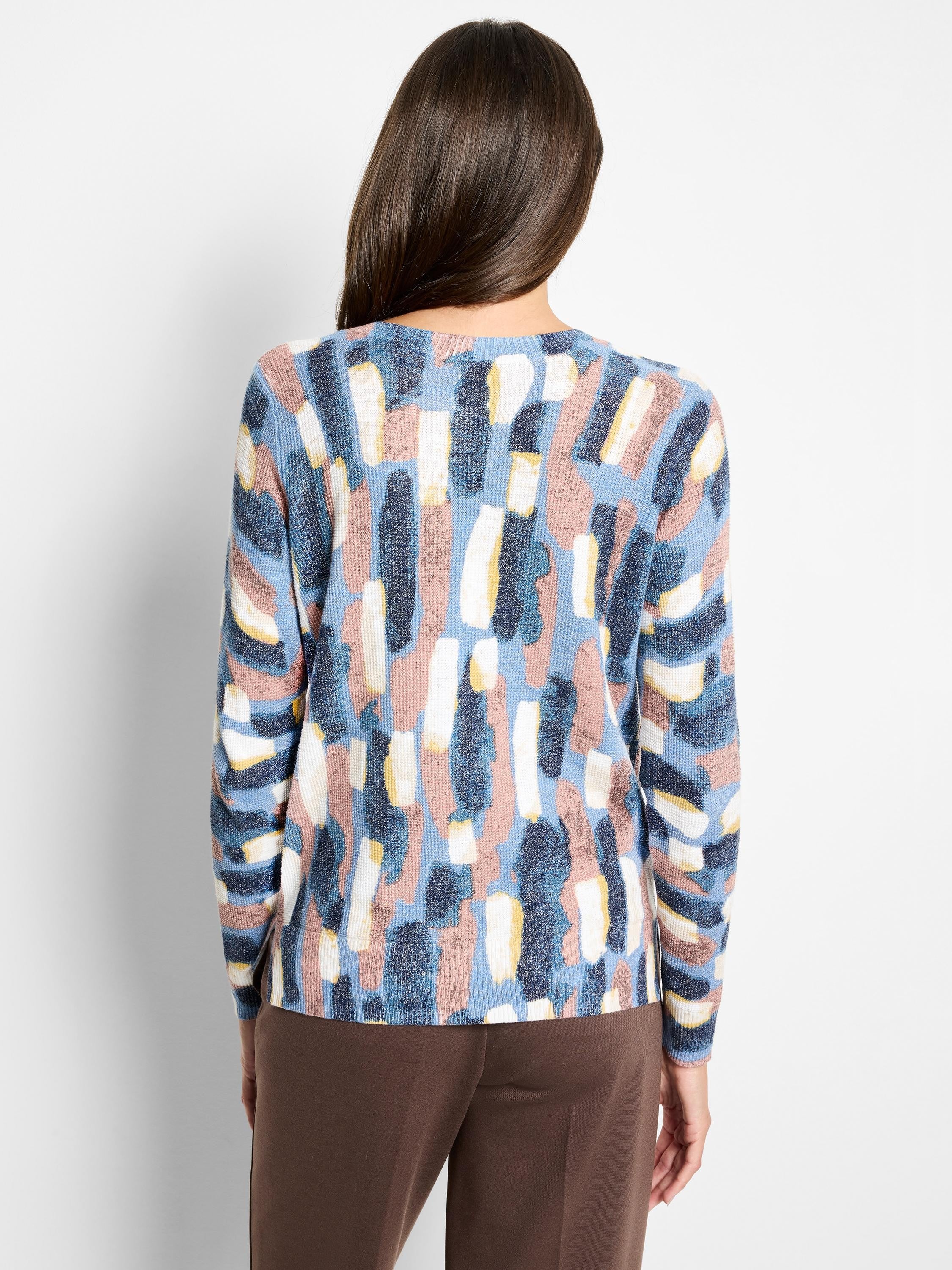 Back view of a waffle knit sweater with abstract blue, pink, white, and yellow brushstroke pattern.