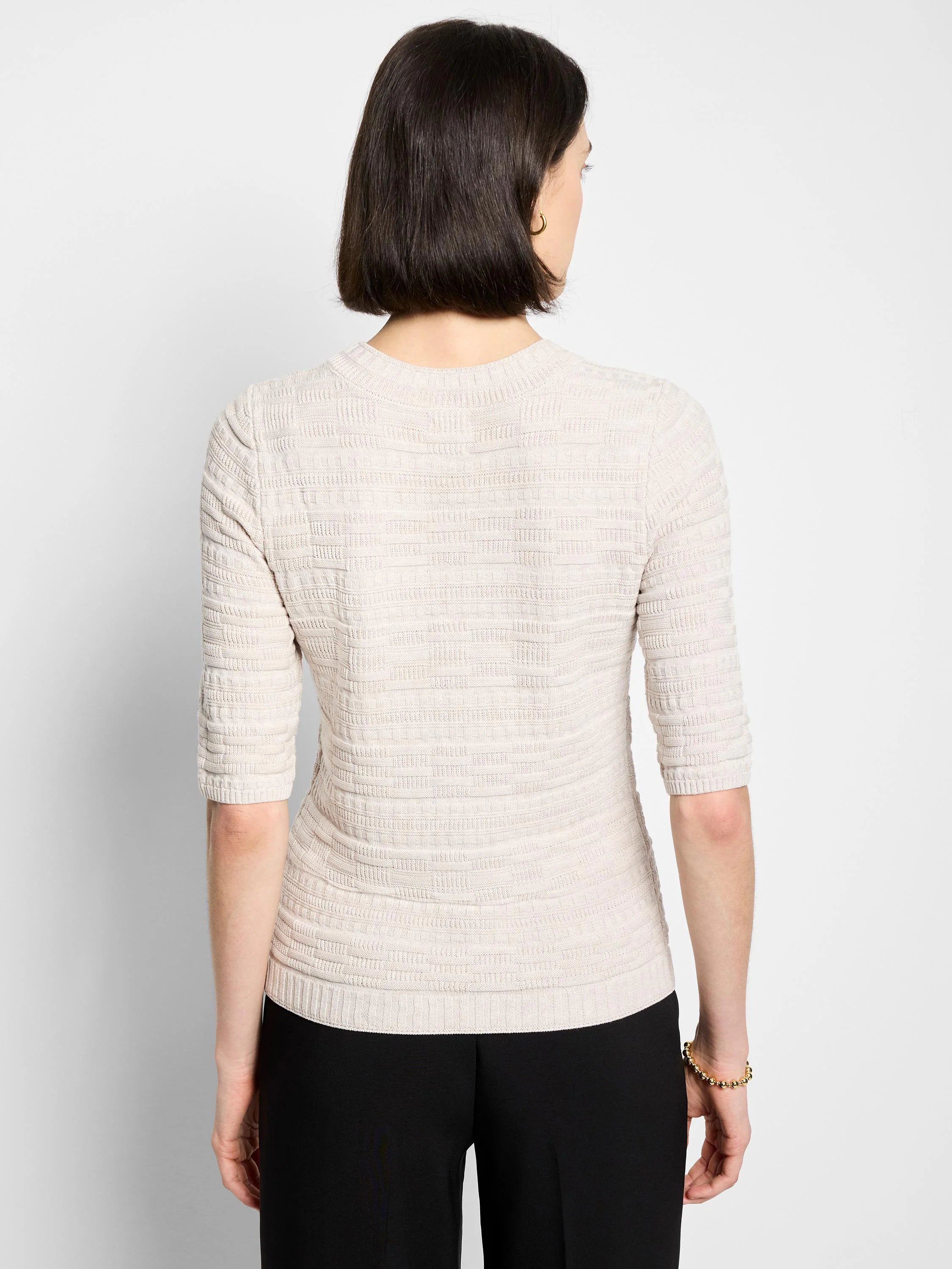 Light beige sweater tee with crew neck, geometric knit pattern, and elbow-length sleeves.