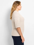 Light beige sweater tee with 3/4 sleeves. Features an all-over geometric textured knit pattern.