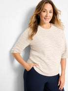 Light beige sweater tee with geometric knit texture, crew neck, and elbow sleeves.