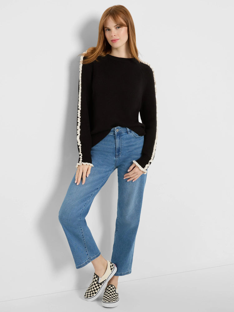 Black sweater with cream ruffles down the sleeves and at the cuffs.