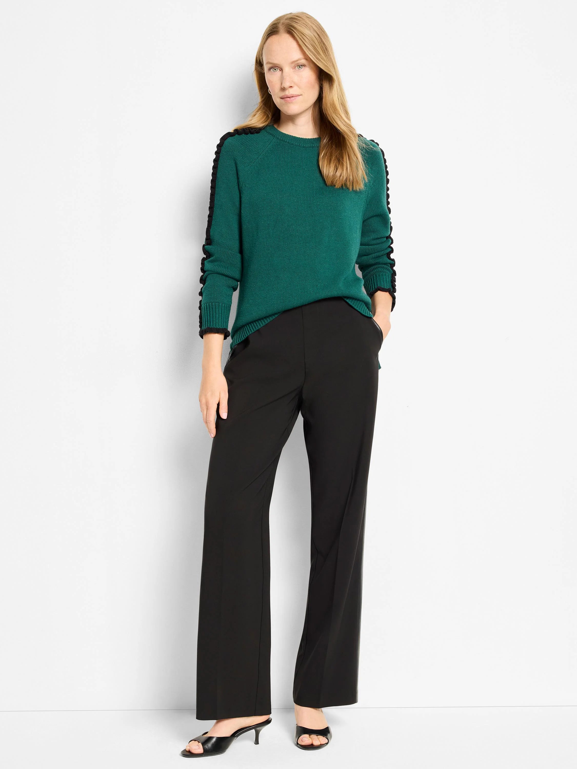 Deep green knit sweater with black ruffled trim along the shoulders and sleeves.