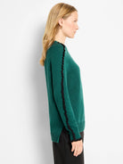 Emerald green sweater with black ruffled trim along the neckline and outer sleeves.