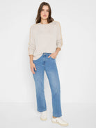 Light beige sweater with tan, textured ruffles running down the outer sleeves.