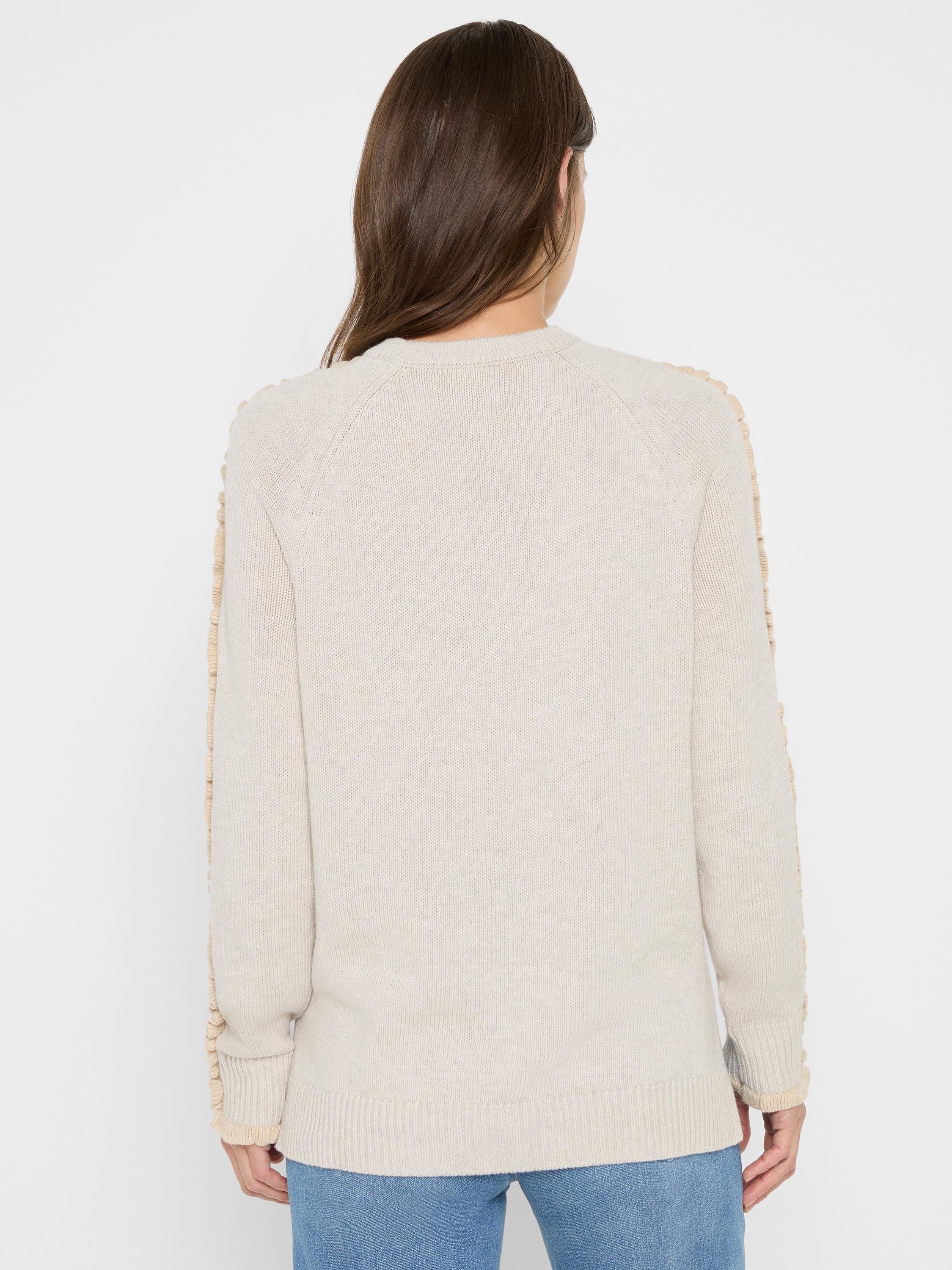 Light beige sweater, back view, with tan ruffles along the long raglan sleeves.