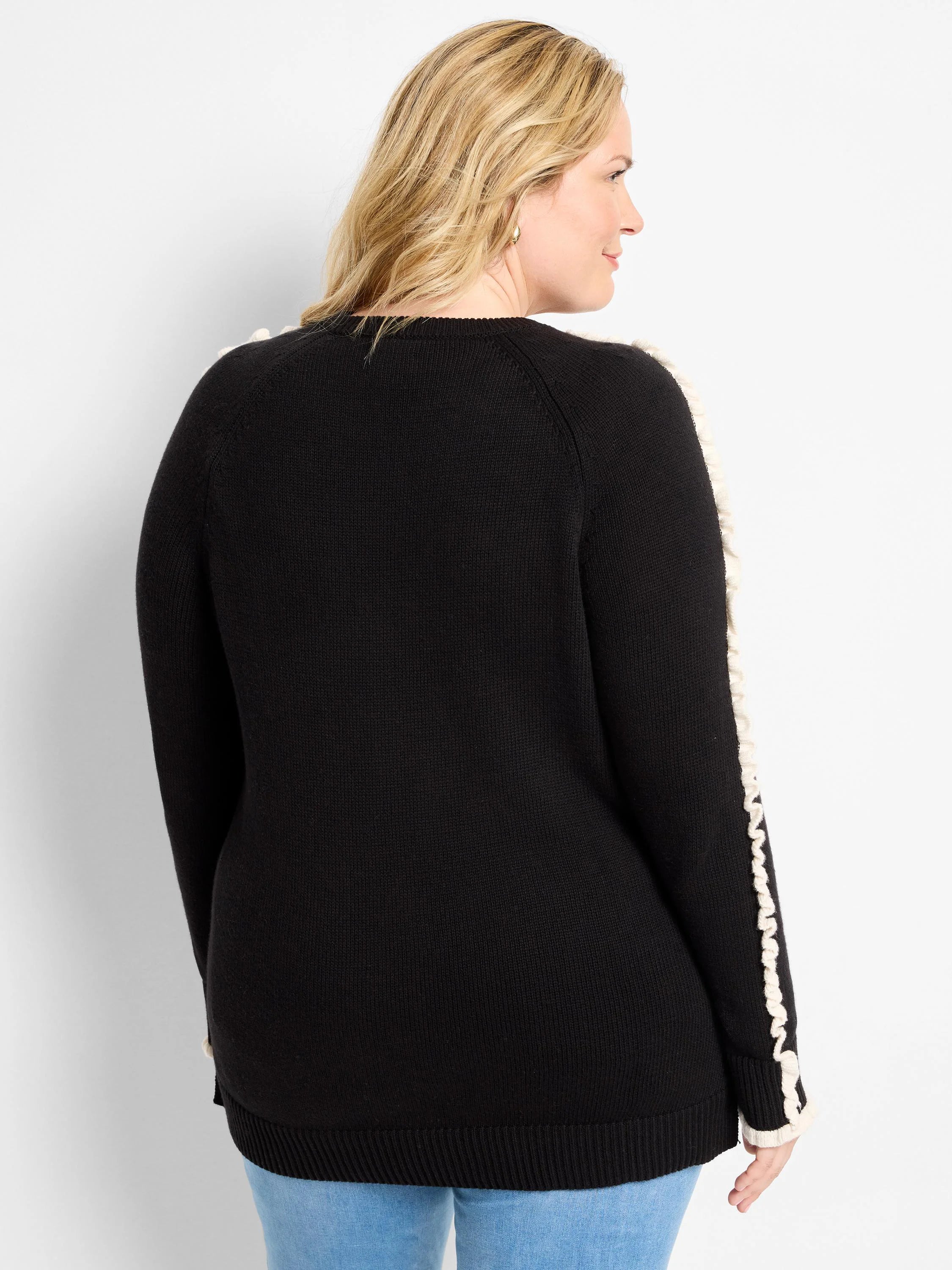 Black sweater with cream vertical ruffles on the outer sleeves and ribbed hem.
