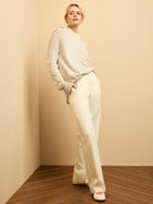 Oatmeal knit sweater with ruffled sleeves and a ruffled mock neck.