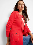 Red knit blazer with white contrast stitching outlining lapels, front edges, and patch pockets.