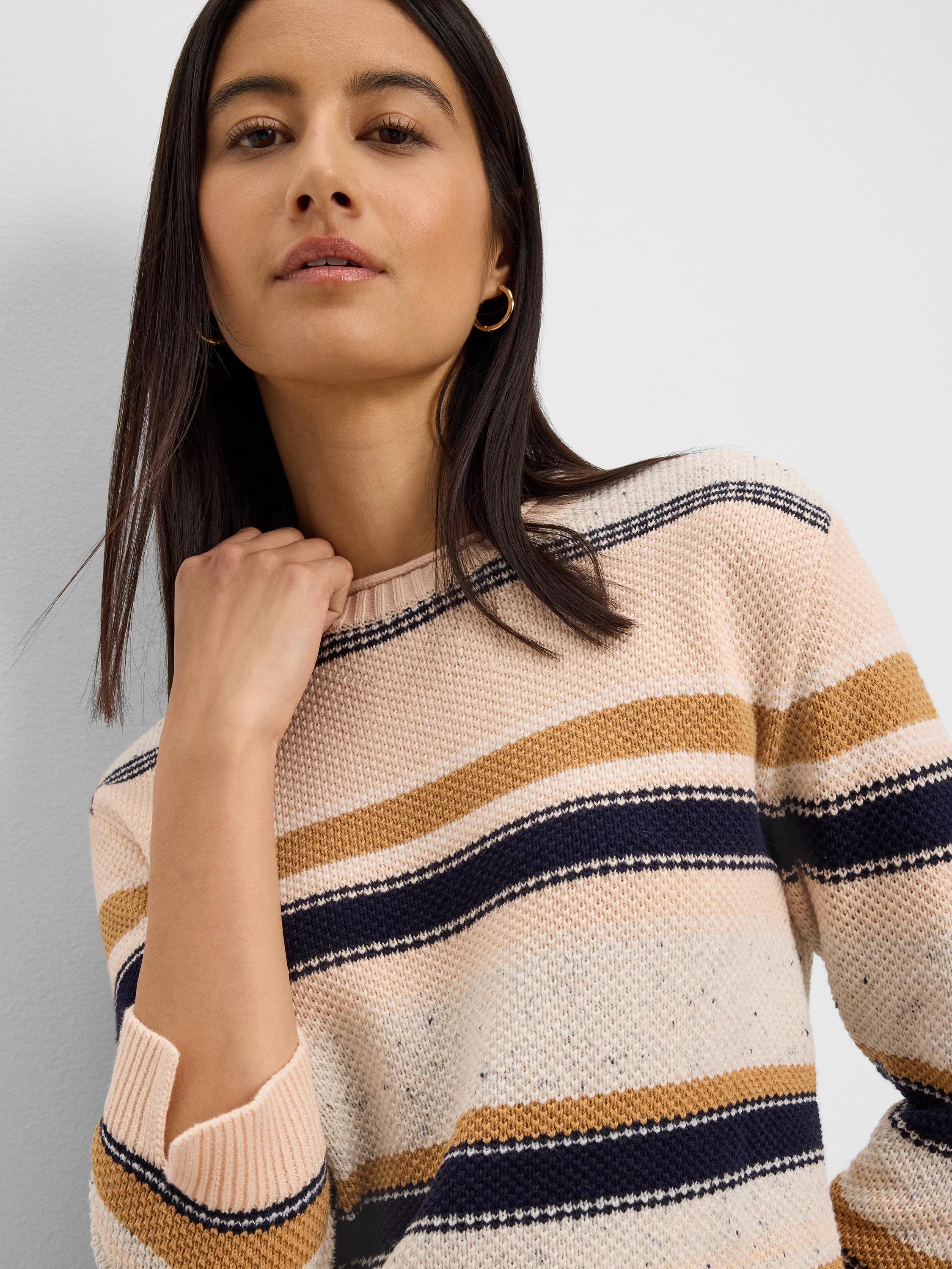 Knit sweater with horizontal stripes in cream, pale peach, navy, and mustard yellow.