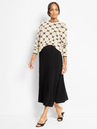 Beige doubleknit sweater with black geometric argyle pattern and black trim on collar and cuffs.