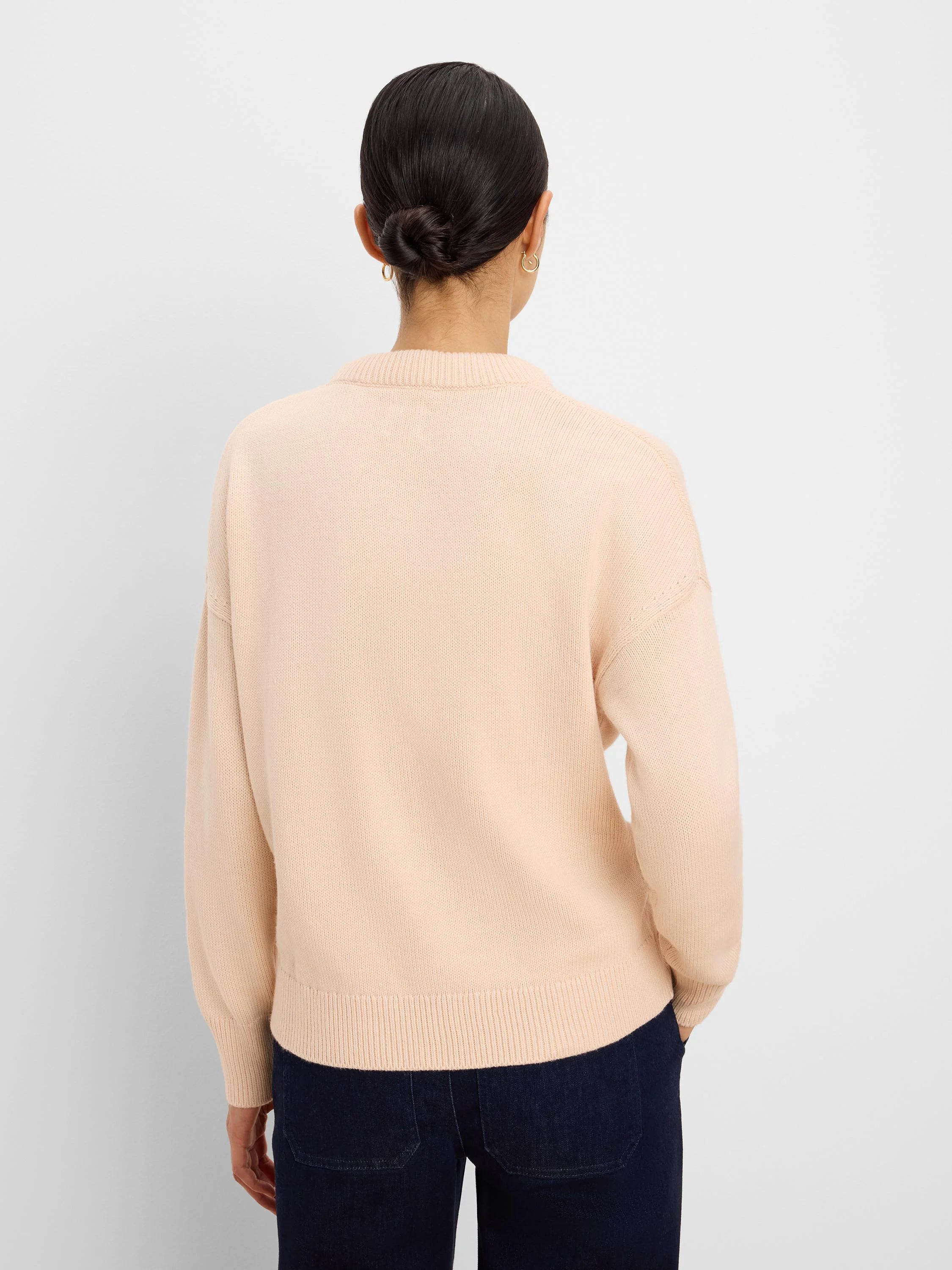 Light peach cotton cashmere sweater, back view, with ribbed neck, cuffs, and hem, loose fit.