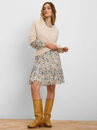 Pale beige deep V-neck knit sweater with ribbed cuffs and hem.