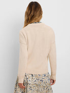 Light beige cotton cashmere sweater, back view. Shows knit texture, ribbed cuffs, hem, and back collar.