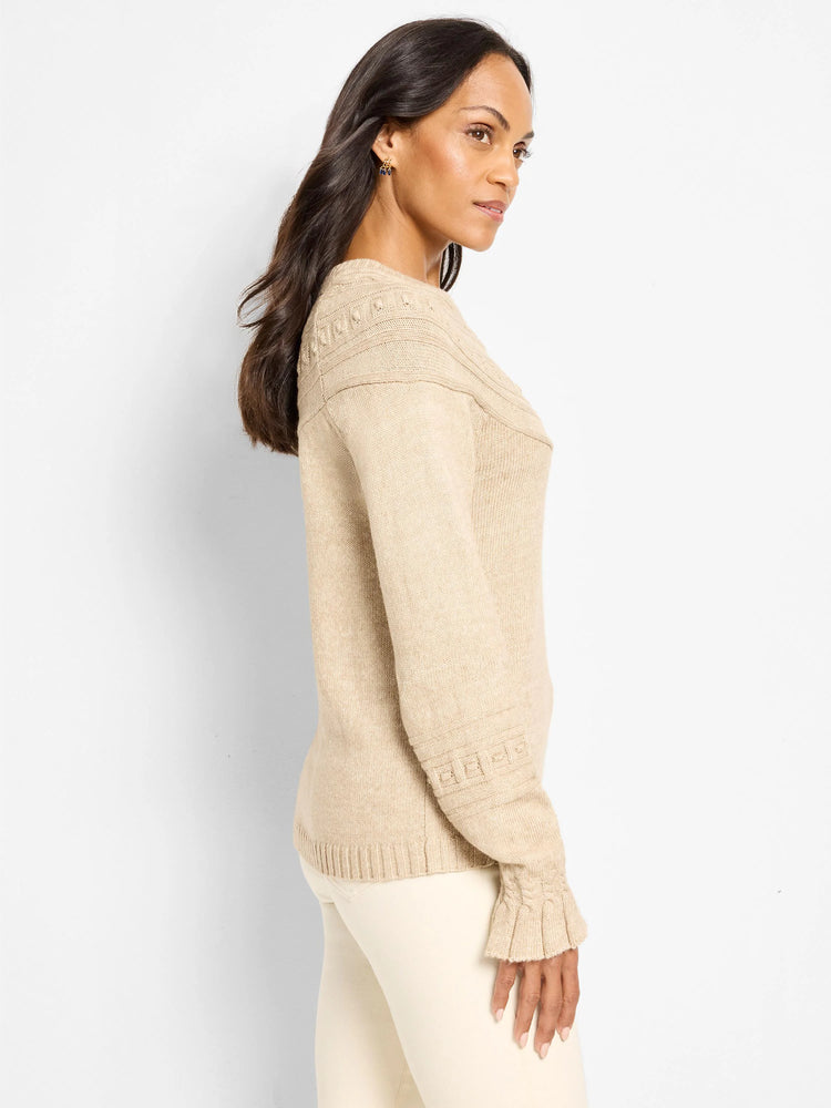 Oatmeal sweater with raised dot patterns on shoulders & sleeves, ribbed hem, & ruffled cuffs.
