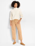 Cream mock neck sweater with a raised diamond texture.