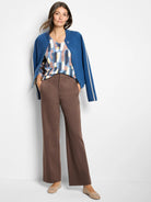 Dusk blue knit bomber jacket with round neckline, tonal buttons, and cream wavy trim on the sleeves.