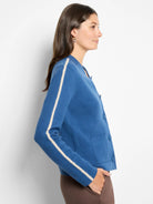 Blue knit bomber jacket with white scalloped sleeve stripes, front buttons & pockets.