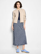 Beige knit bomber jacket with dark blue trim on collar, placket, and sleeves. Button front, two front patch pockets.