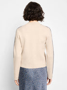 Oatmeal knit bomber jacket, back view. Dark blue piping accents along shoulders and sleeves.